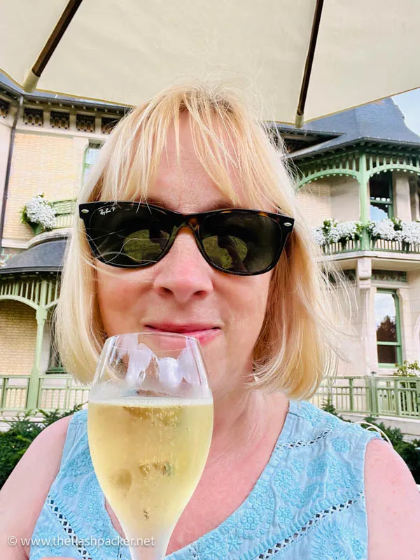 Solo Travel in Europe: The Best Places to Go Alone (2026) 26 woamn in sunglasses holding a glass of champagne