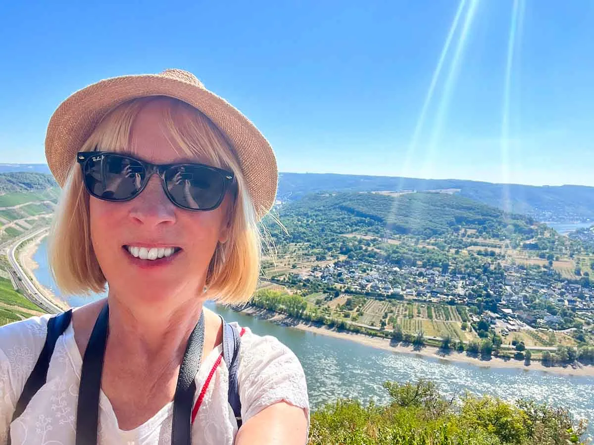 Solo Travel in Europe: The Best Places to Go Alone (2026) 1 woman in sunglasses and hat in front of the rhine valley which is one of the best places to travel alone in europe